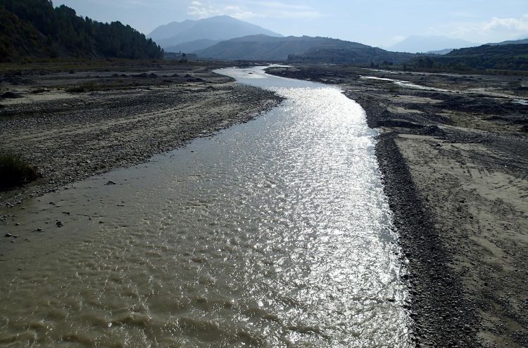 Devoll River flowing in lowland.